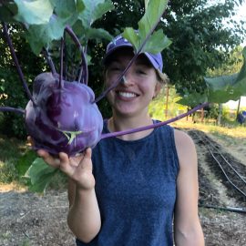 Farm volunteer holding a large purple Kolibri