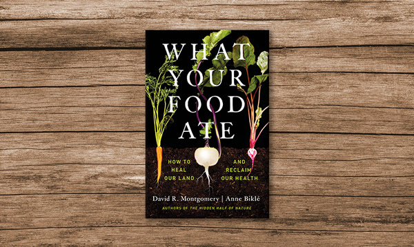 Photo of the book "What Your Food Ate". Cover is a black background with a carrot, turnip, and radish behind the title.